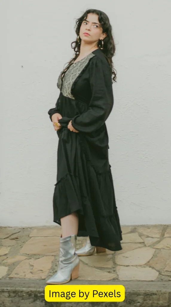 Black maxi dress styled with tan cowboy boots and a brown shoulder bag